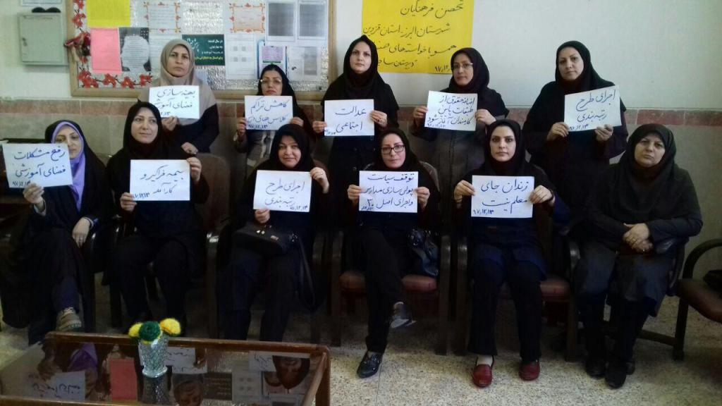 Iranian schoolteachers hold signs in a group photo